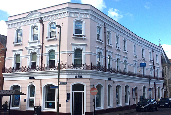 The exterior of The Guildford Institute: a large, two-storey, light pink building.