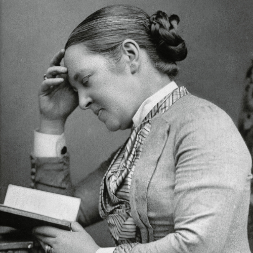 International Women's Day: Portrait of Elizabeth Garrett Anderson. It is a black and white image of Elizabeth, taken side-on, of her sat reading a book. 