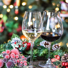 Autumn brochure: two wine glasses in the foreground; one filled with red wine and the other with white wine. Foliage and berries in the background.