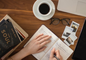 Person writing with coffee