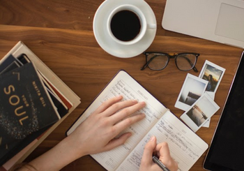 Person writing with coffee