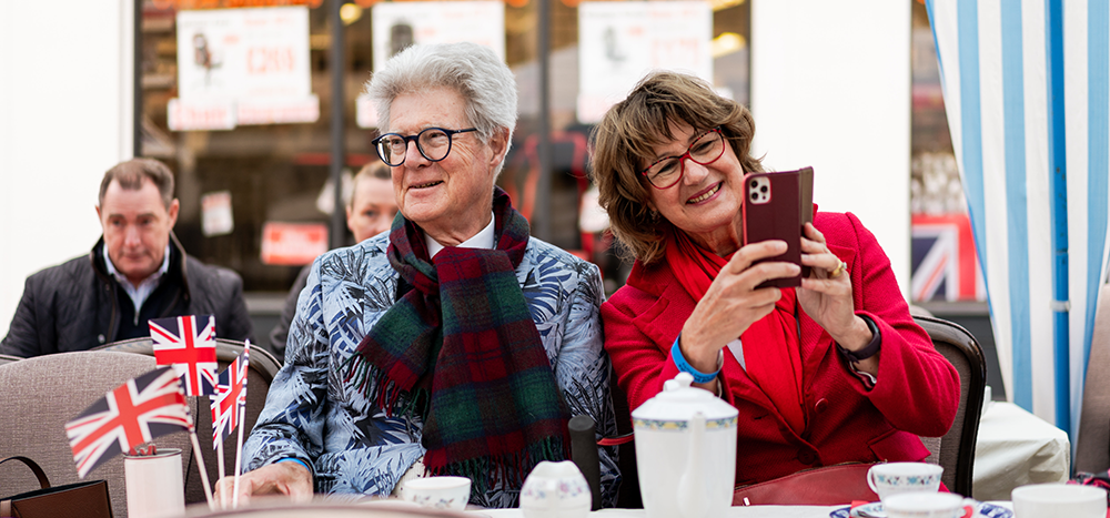 A man and woman sat at a table smiling.